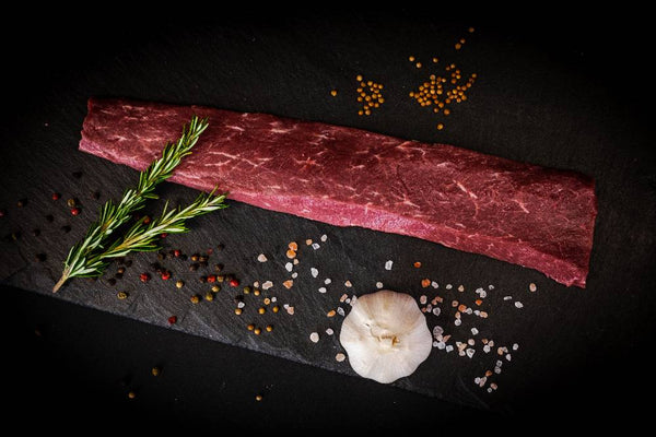 Raw lamb on a slate with ingredients